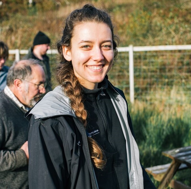Portrait of young woman smiling at camera dressed in outdoor clothing on isle of Skye
