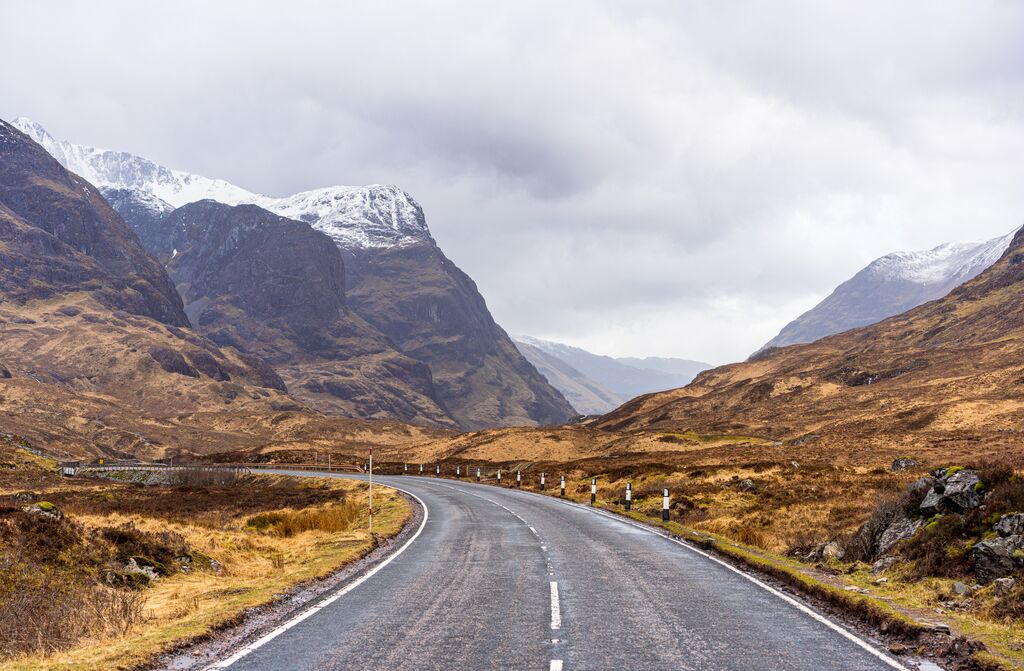 view from the road to Glen Coe valley during with snow-capped mountains