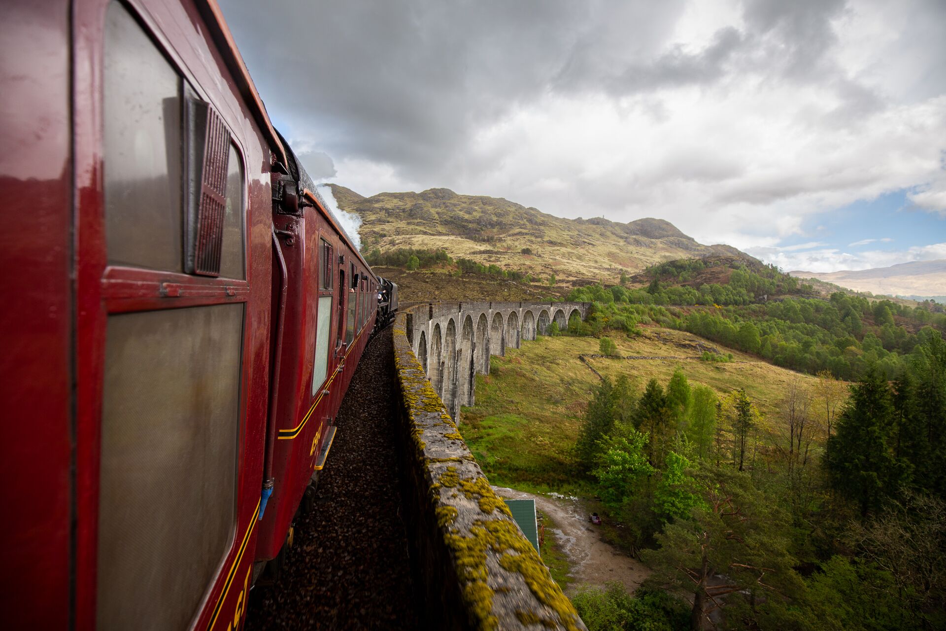 View from close to the Jacobite Steam Train carriage while crossing the Glenfinnan Viaduct, with scenic views