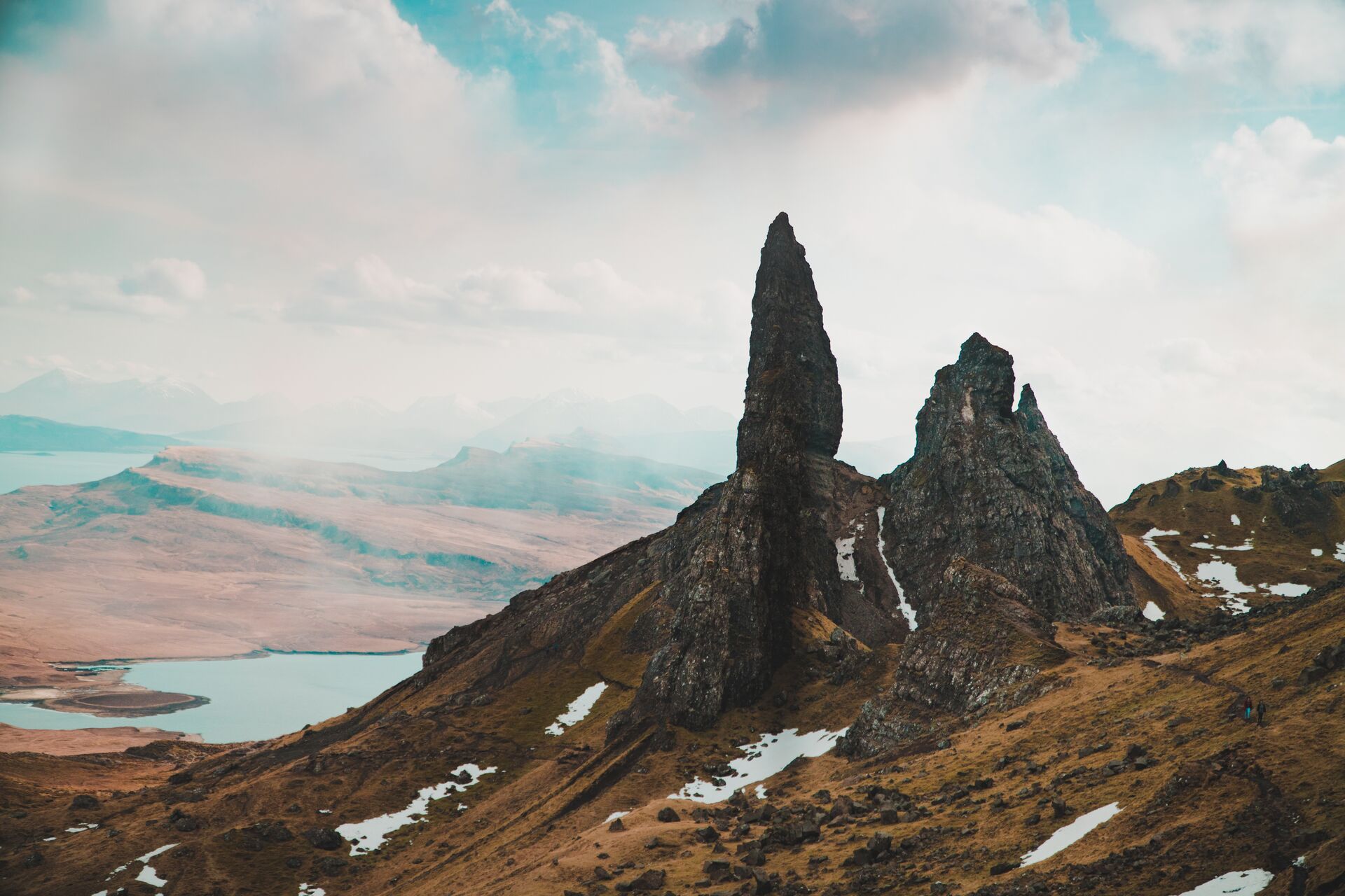Old Man of Storr, rocky spires partially covered in snow, with clear blue skies above