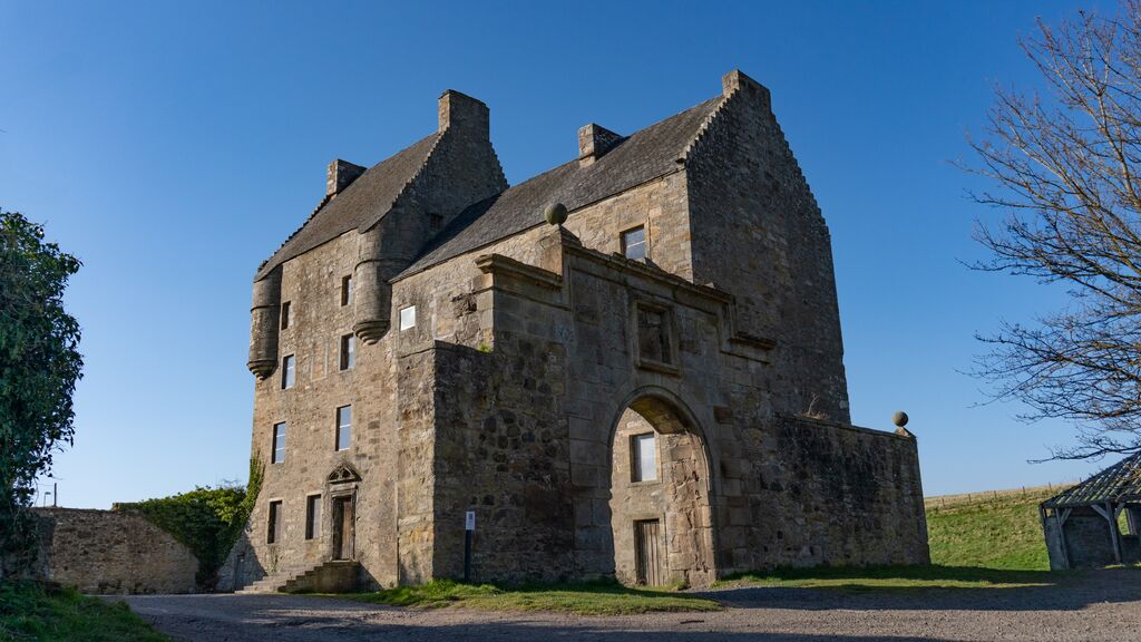 Midhope Castle with stone archway in evening light