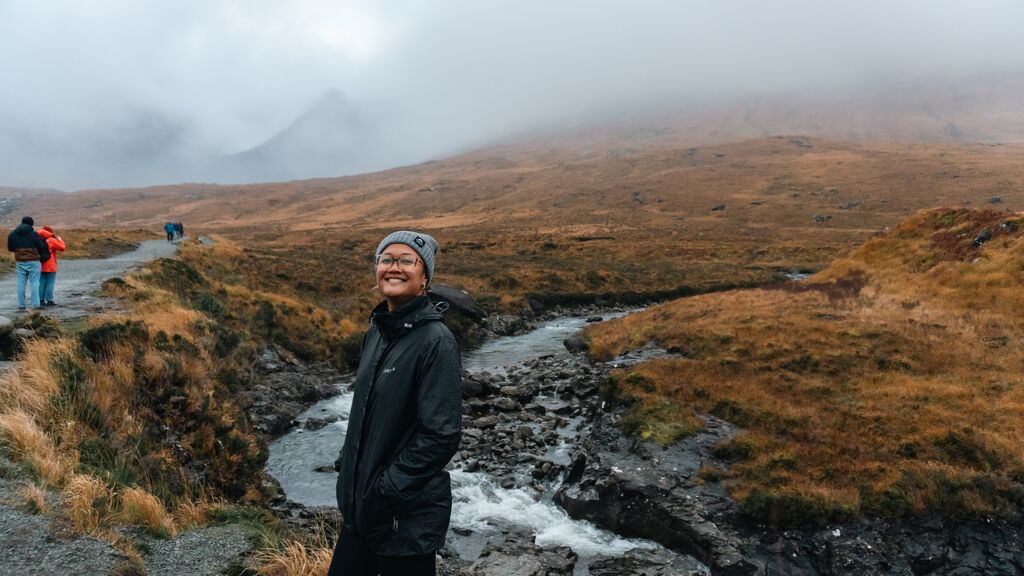 Young woman walking along the Fairy Pools on Isle of Skye